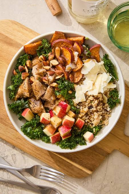 Harvest bowl with roasted sweet potato, kale, chicken, and almonds